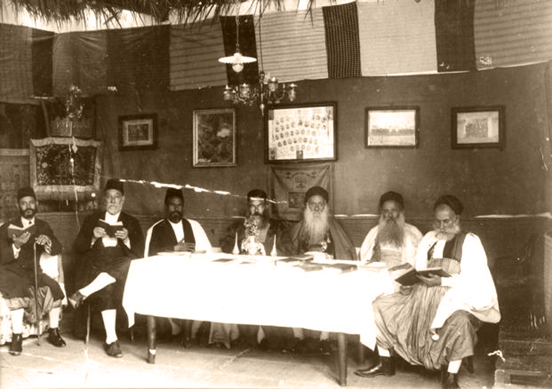 A group of Libyan Jews sitting in a Sukkah during the Jewish holiday of Sukkot. (c) JIMENA